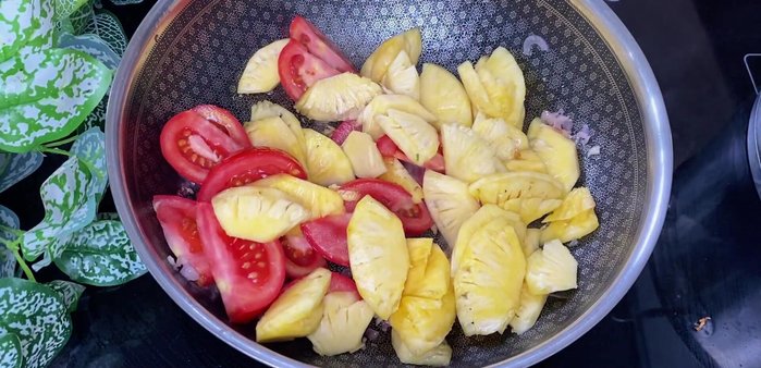 Stir-fry pineapple and tomatoes separately until they are a vibrant color.