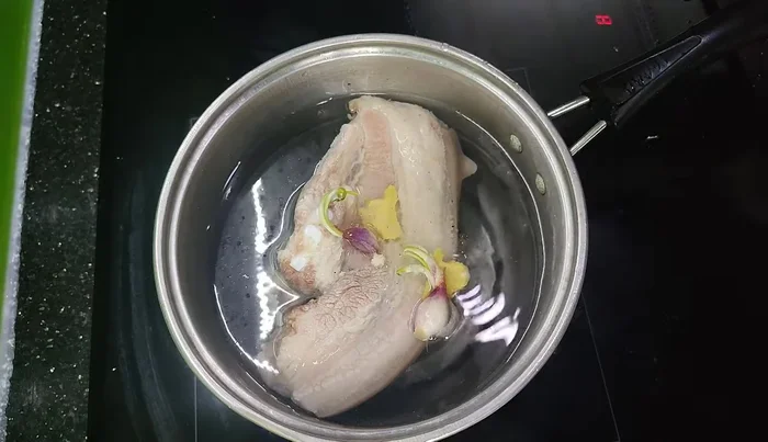 Add shallots, ginger, and a little more salt to the boiling water. This will add fragrance to the meat.