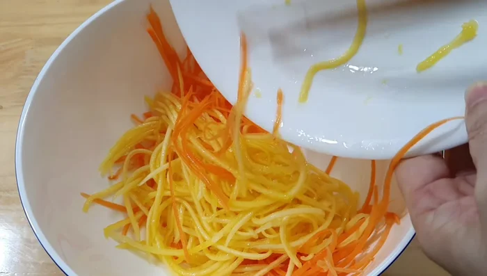 Mix half of the salad dressing with the shredded carrots and mango.