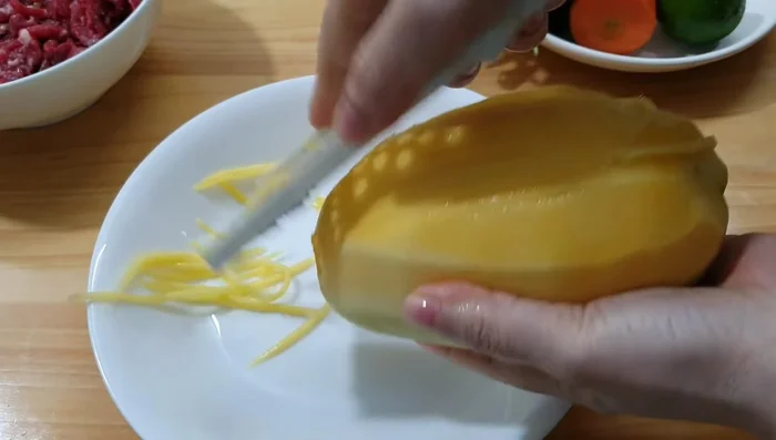 Peel and shred the mango (preferably green mango for a crispier texture). Shred the carrot.