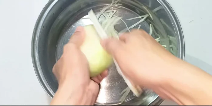Shred the kohlrabi and carrots into long fibers using a peeler.