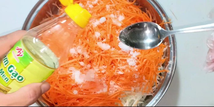 Marinate: Add two spoons of vinegar (rice vinegar is used in the video) and mix well. Let it marinate for about 20 minutes to allow the vegetables to release water.