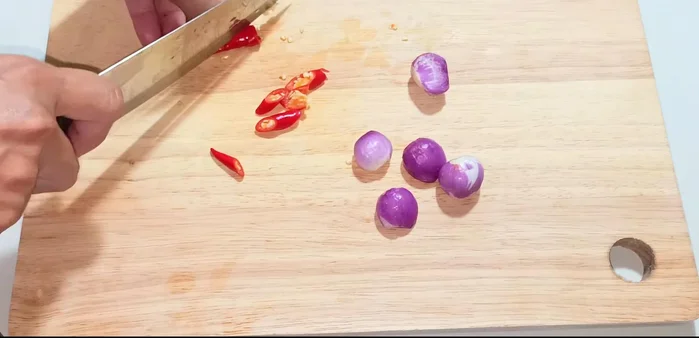 Cut the chili peppers into diagonal slices. Peel and slice the shallots. Finely chop the coriander or green onions.