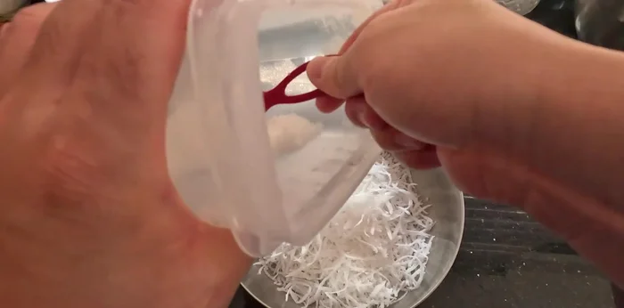 Prepare the coconut filling: Grate coconut into strands, add sugar and salt. Mix well, wrap in plastic, and refrigerate for 30 minutes to absorb sugar. Then stir-fry until cooked.