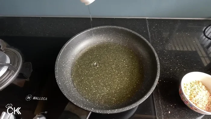 Heat oil in a frying pan. Add lemongrass and fry until fragrant and golden brown. Increase the heat before removing to ensure crispiness. (172.92, 185.319)