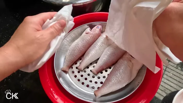After the ice bath, wash the fish again and pat it dry. Make diagonal and horizontal cuts on the fish to help it absorb the marinade. (97.159, 143.48)
