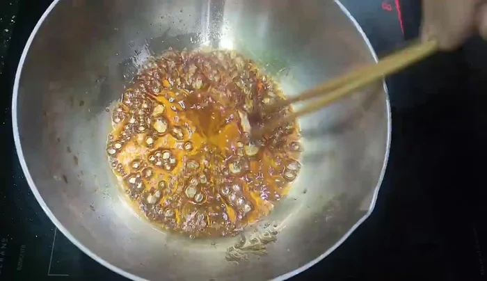 Add the pre-processed pork belly to the caramel.