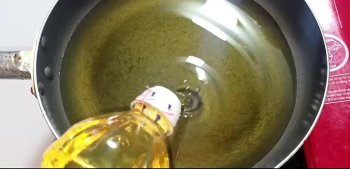 Heat cooking oil in a frying pan over medium heat. Add a spoonful of crispy fried flour (or regular flour/cornstarch/rice flour) to the pan and stir until it's lightly browned. This helps prevent the fish from sticking and splattering.