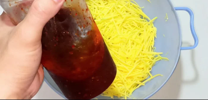 Remove the fried fish and place it in a basket to drain excess oil.