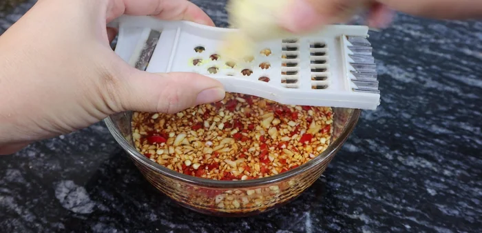 Grate ginger for ginger fish sauce.