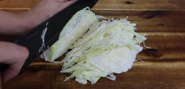 Prepare salad: Thinly slice cabbage, shred banana blossom, carrot, and herbs.
