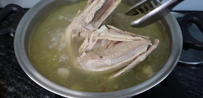 Remove cooked duck meat, let it cool, and then cut it into thin slices.