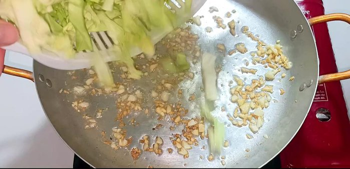 Add cabbage and stir-fry until evenly coated with oil and garlic.