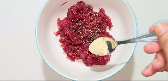Marinate the minced beef with ground pepper, 1/2 teaspoon seasoning powder, 1/3 teaspoon MSG, 1/3 teaspoon sugar, 1 teaspoon fish sauce, and half of the minced garlic. Mix well and let it marinate for about 5 minutes.