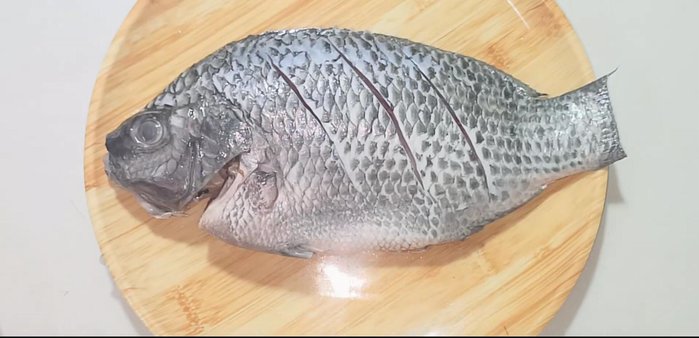 Marinate the fish with the spice mixture, rubbing it evenly to ensure all parts are coated. Stuff some lemongrass into the cuts in the fish.