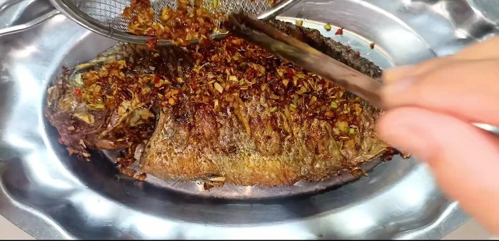 Evenly spread the fried lemongrass, garlic, and chili over the fried fish.