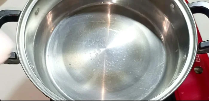 Heat cooking oil in a pot and stir-fry chili peppers until fragrant.