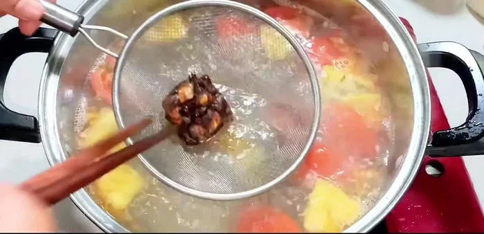 Strain the tomatoes to extract the juice and add it to the soup.