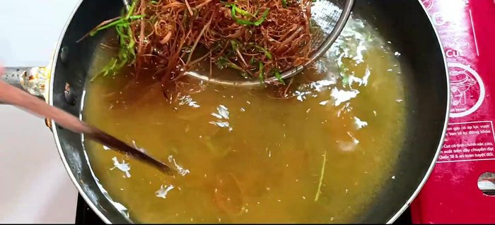 Remove the chicken and lemongrass from the pan using a sieve to drain excess oil.