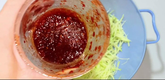 Discard the boiling water and remove the lemongrass and ginger. In a bowl, mix the shredded mango with the Thai sauce until evenly colored.