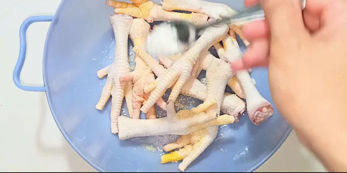 Season chicken feet: Add seasoning powder, MSG, and ground pepper. Mix well and marinate for 30 minutes.