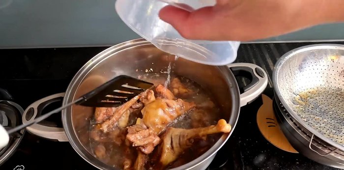 Add the fried chicken to the pan. Pour in 1 liter of coconut water and another cup of water. Season with salt, seasoning powder, and rock sugar.