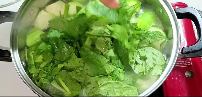 Once boiling again, add the Malabar spinach. Stir to ensure even cooking.