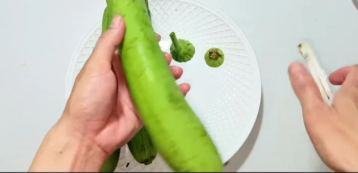 Cut off both ends of the squash and peel off the green skin using a peeler.
