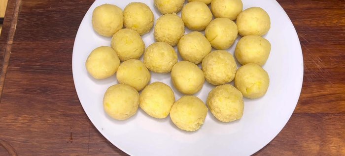 Assemble the Banh It: Let the dough rest. Form small balls of the mung bean filling (approx. 30g) and larger balls of the dough (approx. 60g).