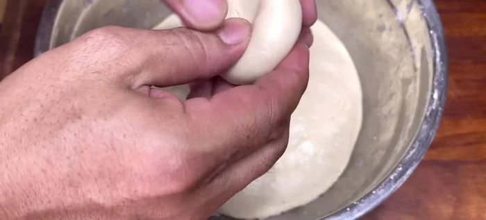 Wrap the cakes: Make a well in the dough ball, add the filling, and close the dough around it, shaping it into a ball. Dip the dough in oil to prevent sticking.