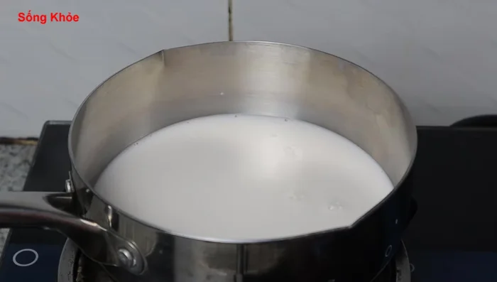 Prepare the coconut milk: Combine 400ml coconut milk (from about 400g of grated coconut), 50g of sugar, a pinch of salt, and 2 teaspoons of rice flour mixed with a little water. Add pandan leaves for fragrance. Simmer until boiling. (152.92, 160.519, 165.879, 169.76)