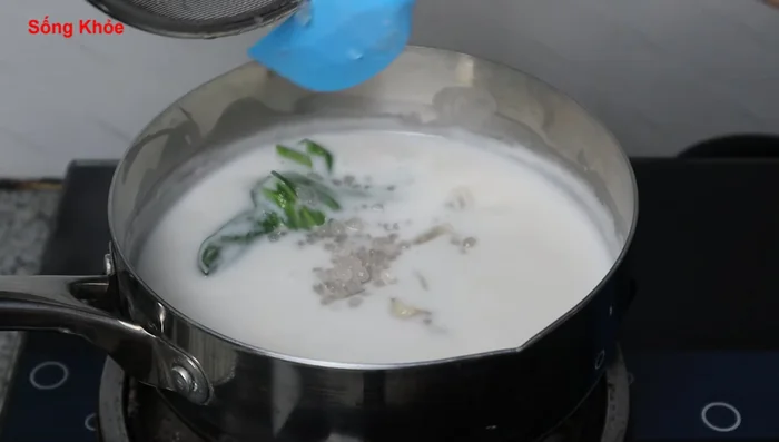 Add tapioca starch to the boiling coconut milk, ensuring it cooks thoroughly. Stir for about 1 minute until the coconut milk thickens. (190.599, 204.239)