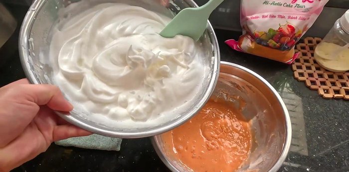 Gently fold about 1/4 of the beaten egg whites into the yolk mixture to lighten it. Then, gently fold the yolk mixture into the remaining egg whites, mixing in one direction from the bottom up.