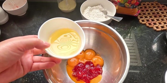 In a bowl, combine egg yolks, 70g cooking oil, and strawberry jam (mashed if using whole strawberries). Mix well.