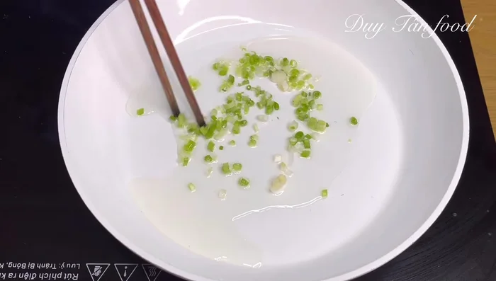 Sauté onion whites: Heat cooking oil in a pan over medium heat. Add the chopped white parts of the green onions and sauté until fragrant.