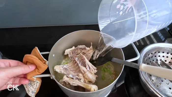 Add blanched chicken bones and 600ml of water to the pot with the aromatics. Simmer over low heat for 30 minutes, uncovered.