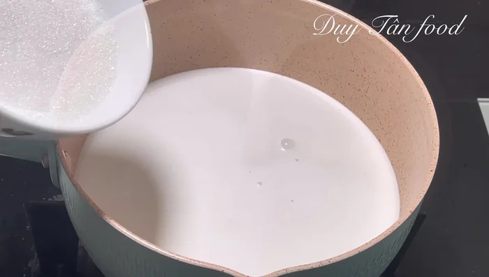 Cook the coconut milk: In a pot, combine 400 ml of canned coconut milk (cream), 100g sugar, and 1/3 teaspoon of salt. Stir well and cook over medium heat until the sugar dissolves and the mixture simmers slightly (about 5 min).