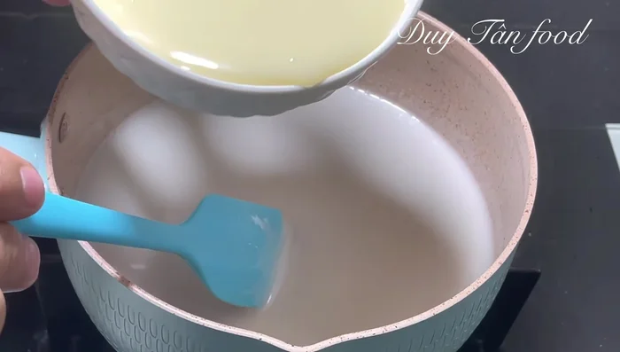 Add 300g milk to the simmering coconut milk mixture. Reduce heat to low, stir constantly, and cook for another minute until it simmers again. Turn off the heat and let cool.