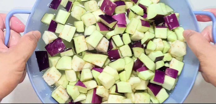 Wash the soaked eggplants thoroughly three times with water to remove the black substance.