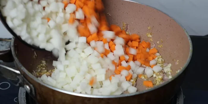 Stir-fry garlic and shallots until fragrant. Add cassava and carrots, season with sugar, MSG, salt, and pepper.