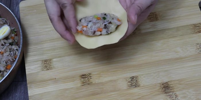 Place a spoonful of filling in the center of each dough circle. Wrap tightly and seal the edges.