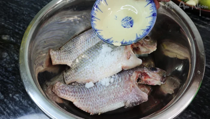 Clean the fish: Wash tilapia fish thoroughly. Add salt, white wine, water, and half a lemon (or vinegar) to a basin. Soak the fish for about 5 minutes to remove slime and fishy smell. Rinse the fish two or three times until clean.