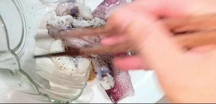 Pour out the marinated squid. (155.879)