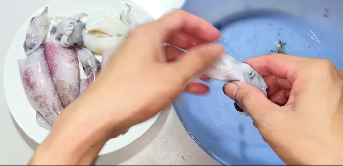 Clean the squid: remove the head, ink sac, and internal organs. Be careful not to break the squid. (90.799)
