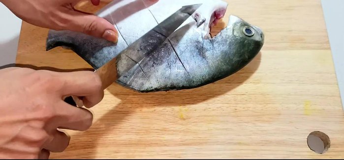 Score the pomfret with diagonal lines to help with marinating and cooking.