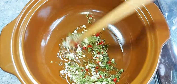 Heat oil in a clay pot and sauté minced garlic, chili, and lemongrass until fragrant.