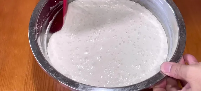 Gently stir the risen batter to remove large air pockets.