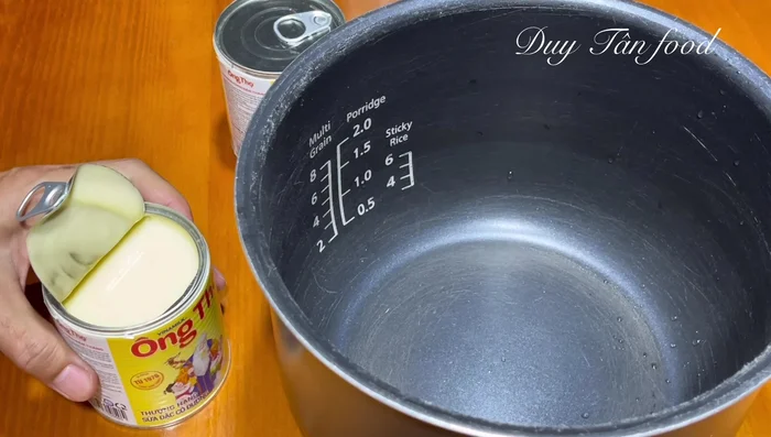 Pour the two cans of milk into the warmed pot.