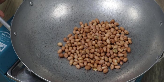 Roast peanuts in a pan over medium heat until golden brown. Reduce heat to low as needed.