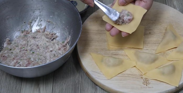 Place a spoonful of filling in the center of each square. Brush the edges with water, fold, and seal to form wontons.